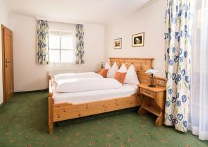 a bedroom with a wooden bed and a window at Bauerndörfl Hüttschlag in Hüttschlag