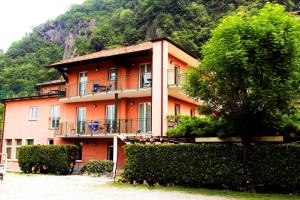 duży pomarańczowy budynek z drzewem przed nim w obiekcie Apartment Lake Maggiore - ITALIA w mieście Maccagno