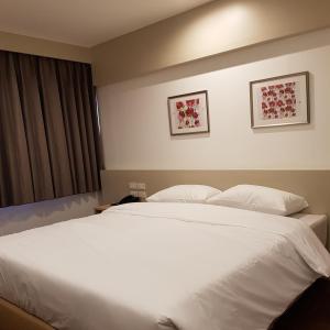 ein Schlafzimmer mit einem großen weißen Bett mit zwei Kissen in der Unterkunft Florida Hotel in Bangkok