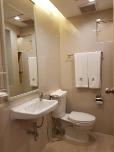 ein Badezimmer mit einem WC, einem Waschbecken und einem Spiegel in der Unterkunft Florida Hotel in Bangkok