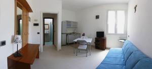 salon z niebieską kanapą i stołem w obiekcie Apartment Lake Maggiore - ITALIA w mieście Maccagno