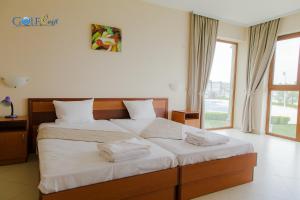 1 Schlafzimmer mit 2 Betten und weißer Bettwäsche in der Unterkunft Aparthotel Golf Coast in Kawarna