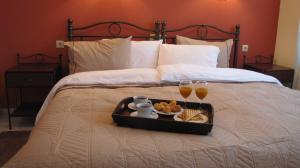 - un plateau de nourriture sur un lit avec boissons et collations dans l'établissement Salvia, à Loutra Amarantou