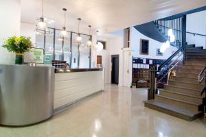 a lobby of a building with a counter and stairs at Hotel Xaine Park in Lloret de Mar +37 photos