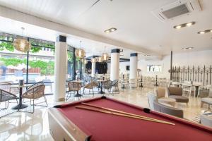 a pool table in a room with tables and chairs at Hotel Xaine Park in Lloret de Mar