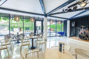 a restaurant with tables and chairs and windows at Hotel Xaine Park in Lloret de Mar