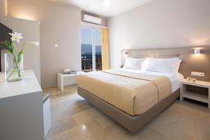 a bedroom with a large bed and a window at Adriatica Hotel in Nikiana