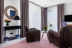 グディニャにある7th Floor Rooms & Apartments Gdyniaのリビングルーム(椅子2脚、鏡付)