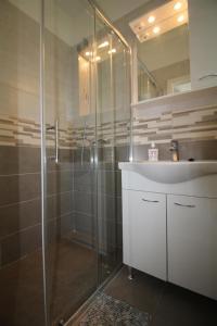 a bathroom with a glass shower and a sink at Private Accommodation Carevic in Dubrovnik