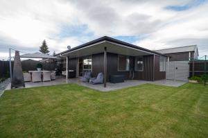 a house with a patio and a yard at Luxury Rata Apartment - A in Twizel