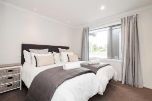 2 Betten in einem weißen Zimmer mit Fenster in der Unterkunft Luxury Rata Apartment - A in Twizel