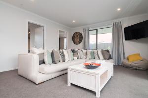 uma sala de estar com um sofá branco e uma mesa em Luxury Rata Apartment - A em Twizel