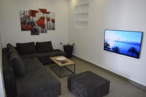 a living room with a couch and a tv on a wall at Bozikovic 365 in Podstrana