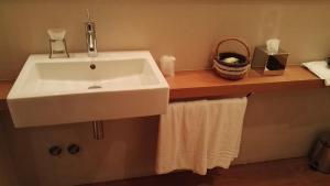 a bathroom with a sink and towels on a wooden shelf at Mario's Garni in Pescocostanzo