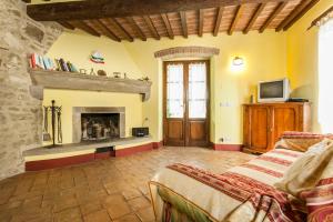 een woonkamer met een open haard en een bed bij Holiday apartments La Bozza and Il Bozzino in Cortona
