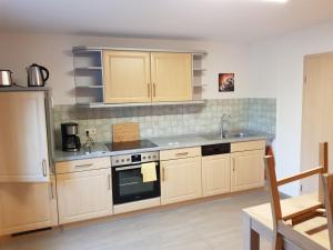 a kitchen with wooden cabinets and a stove top oven at Störmthal Ferienwohnung 1 Sonnenweg in Störmthal