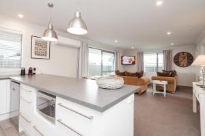 a kitchen with a counter and a living room at Luxury Rata Apartment - B in Twizel