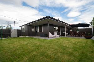 a small house with a lawn in front of it at Luxury Rata Apartment - B in Twizel