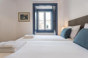 リスボンにあるFLH Mouros Comfortable Placeの窓付きの客室で、白いベッド2台が備わります。