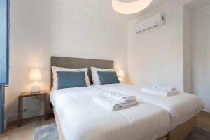 リスボンにあるFLH Mouros Comfortable Placeのベッドルーム(青い枕の大きな白いベッド付)