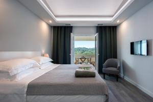 a bedroom with a large bed and a television at Gem Villa in Viros Corfu in Virós