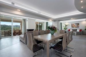a dining room with a wooden table and chairs at Gem Villa in Viros Corfu in Virós