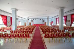 an empty hall with red chairs and a red carpet at Hotel Dar Eddaya in Khemisset