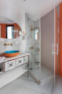 a bathroom with a glass shower and a sink at Sato Design Hotel in Çeşme