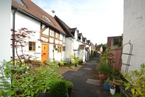 a row of white houses with plants on a street at Abbey Cottage in Shrewsbury