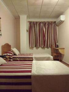 Łóżko lub łóżka w pokoju w obiekcie Hotel Mesón el Castillo