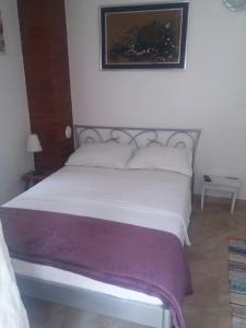 Mate Apartments في قشتيلا: سرير بشرشف ووسائد بيضاء في غرفة النوم