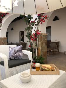 a patio with a table with a sandwich and an umbrella at Domu Elvira in Muravera