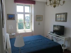 a bedroom with a blue bed and a television at Horvath Villa Apartman Aliz in Balatonfüred
