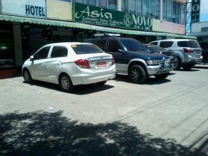 un groupe de voitures garées sur un parking dans l'établissement Asia Novo Boutique Hotel - Roxas, à Roxas City