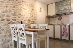 a kitchen with a wooden table and white chairs at Lavanda in Tribunj +44 photos