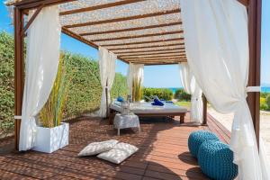 a pergola with a bed on a patio at Sa Platja in Playa de Muro
