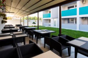a restaurant with tables and chairs and a lawn at Turquoise Boutique Mamaia Nord in Mamaia Sat/Năvodari