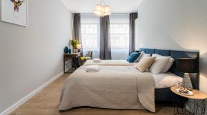 a bedroom with a large bed and a blue couch at Vistula Boutique Exclusive Apartments in Krakow