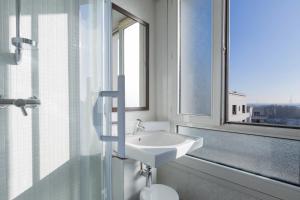 uma casa de banho branca com um lavatório e uma janela em Best Western Rives de Paris La Defense em Courbevoie