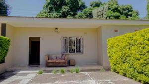 a couch sitting on the porch of a house at Avon Garden Lodge in Salima