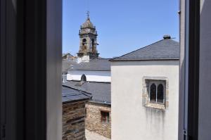 a view from a window of a building with a clock tower at Cantábrico Fonsagrada in Fonsagrada
