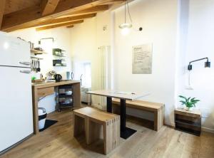 uma cozinha com uma mesa, uma secretária e um frigorífico em Locanda alla Beccherie em Trieste