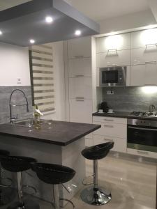 a kitchen with a counter and two bar stools at Gutenberg Apartments in Szeged