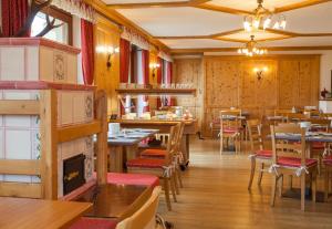 een restaurant met houten muren en tafels en stoelen bij Hotel Vallée Blanche Courmayeur in Courmayeur