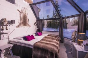 um quarto com uma cama e uma grande janela em Santa's Hotel Aurora & Igloos em Luosto