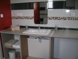 ein Badezimmer mit Waschbecken und Spiegel in der Unterkunft M. Clemenceau - Les Maisonnettes De La Maneliére in La Flocellière