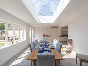 a dining room with a table and chairs and a skylight at South Winds in Bourton on the Water