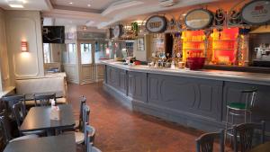 a bar in a restaurant with tables and chairs at Hôtel Les Frangins in Saint-Omer