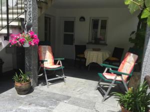 a patio with two chairs and a table with flowers at Ca Evelina in Maggia