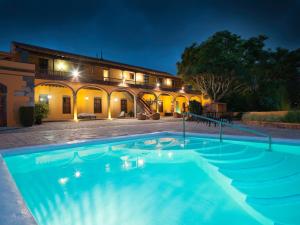 a swimming pool in front of a building at night at Hotel Rural Hacienda del Buen Suceso in Arucas